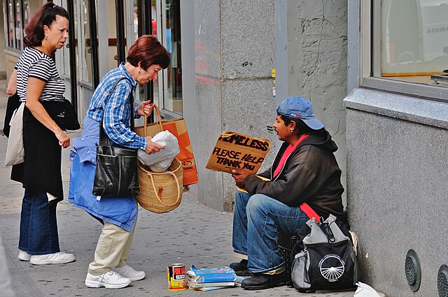 Photograph of a homeless man holding a sign by Ed Yourdon, New York City, New York.